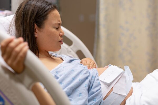 A Pregnant Woman Lying In The Hospital Bed Being Monitored