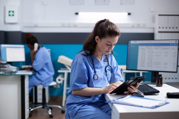 Young Nurse Checking Appointments List On Digital Tablet