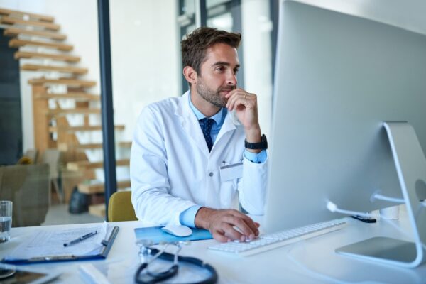 Hospital Doctor On Computer In Office