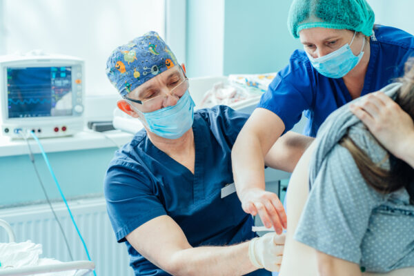 Epidural Shot. Nurse Comforting Pregnant Woman