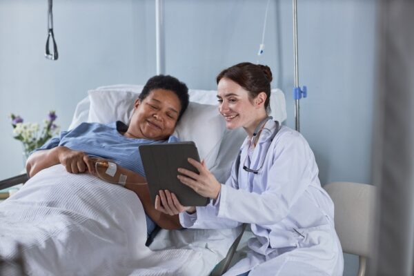 Nurse Showing Digital Tablet Screen To Patient